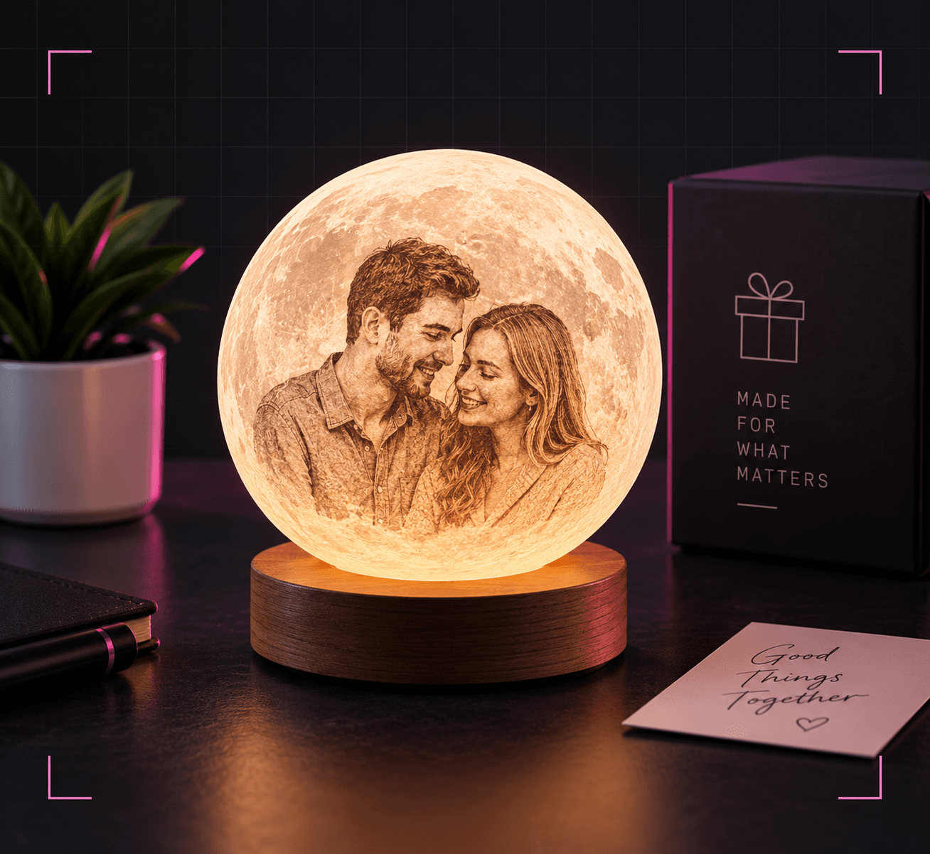 A photo-engraved moon lamp glowing on a wooden base, beside a gift box and a handwritten card